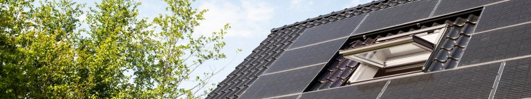 Dak met open raam en zonnepanelen.