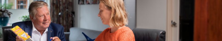 Een man en een vrouw aan tafel tijdens een gesprek over energiebesparing