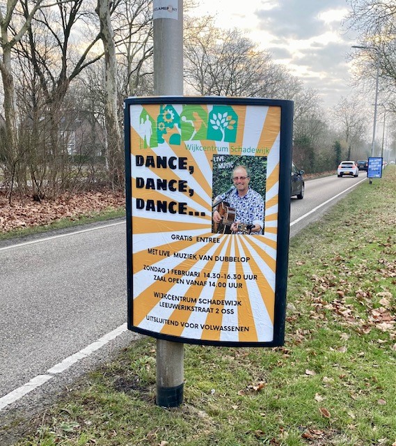 reclamebord aan lantaarnpaal langs de weg