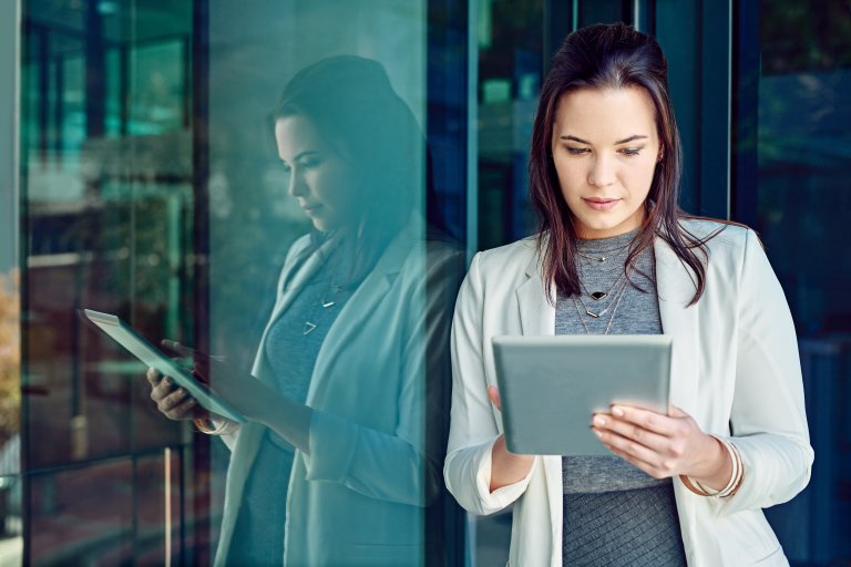 vrouw op een tablet voor een gebouw